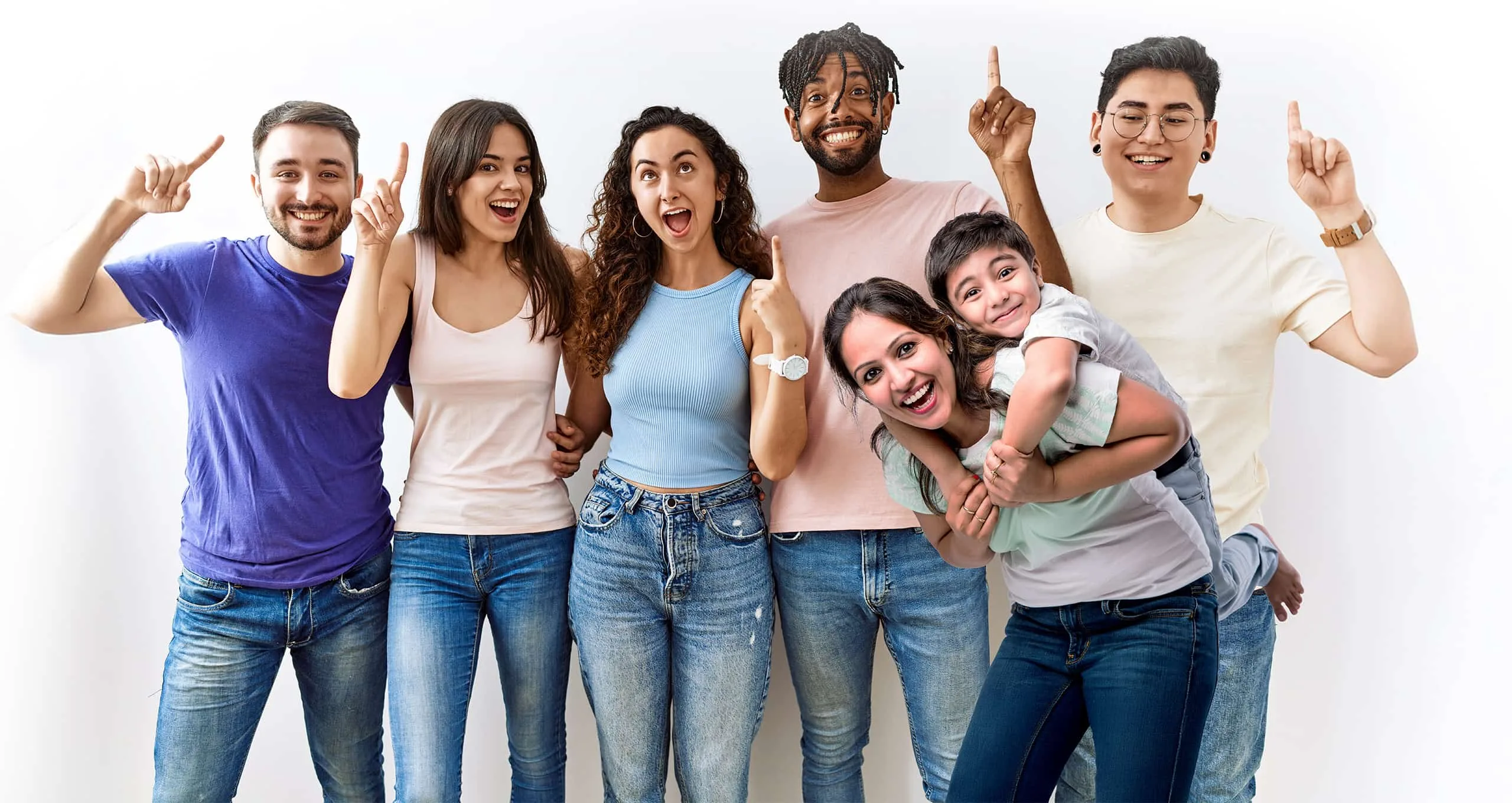 A diverse group of smiling people pointing upward, including a woman giving a child a piggyback ride