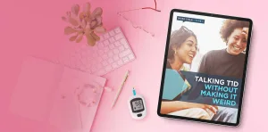 A tablet displaying the 'More Than Type 1' guide titled 'Talking T1D Without Making It Weird,' surrounded by a pink keyboard, succulent plant, notebook, pen, and a blood glucose meter showing 96 mg/dL, all arranged on a pink background